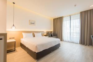 a hotel room with a bed and a desk at Madison Bangkok Hotel in Bangkok