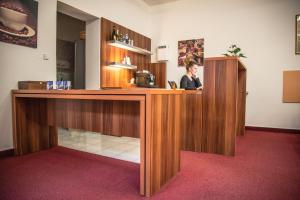 a woman standing at a counter in a room at Hotel U Dómu sv. Václava in Olomouc