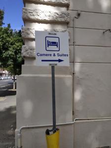 a sign for a camera and suites on the side of a building at Gemini camere e suites in Grosseto
