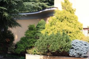 a group of trees and bushes in front of a building at Polo Hotel in Usmate Velate