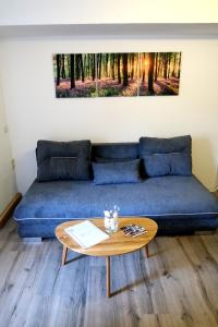 ein Wohnzimmer mit einem blauen Sofa und einem Tisch in der Unterkunft Haus zum Römer in Arnstadt