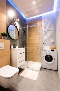 a bathroom with a toilet and a washing machine at NOVUM Apartment in Krakow