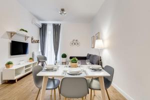 ローマにあるGermanico Luxury Apartmentのダイニングルーム(白いテーブル、椅子付)