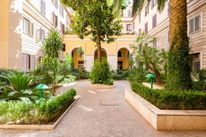 a courtyard of a building with trees and plants at Germanico Luxury Apartment in Rome