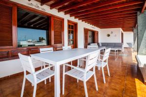 a dining room with a white table and white chairs at Magnífica Villa al lado del mar in Arrecife