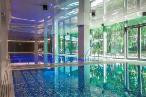 a large swimming pool in a building with windows at Gwiazda Morza Resort SPA&SPORT in Władysławowo