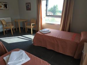 um quarto de hotel com duas camas e uma janela em Hostal restaurante la concordia em Fuentes Claras