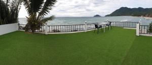 a balcony with a green lawn next to the ocean at Simple Life Cliff View Resort in Koh Tao