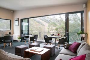 a living room with a couch and chairs and a large window at Diana Alpine Lodge in Falls Creek