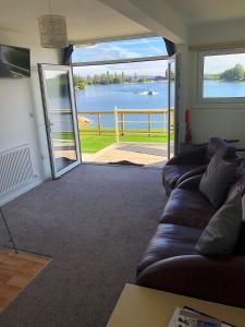 a living room with a couch and a view of the water at Premium Lake Lodges in Chichester