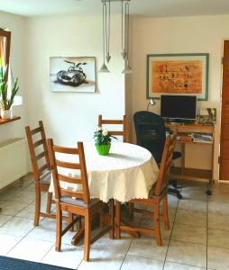 a dining room with a table and chairs and a desk at Sonnenbühl Inn Suite & Garden an den Thermen '35C' in Bad Ditzenbach