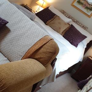 a bedroom with two beds with pillows at The Nest at Bramble Cottage Lacock in Lacock