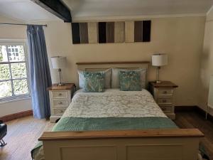 um quarto com uma cama com duas mesas de cabeceira e dois candeeiros em The Mill Hotel em Stone