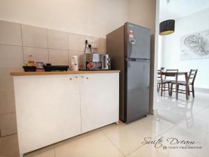 a kitchen with white cabinets and a refrigerator at Suite Dream@Icon Residence in Kuala Terengganu