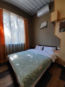 a bedroom with a bed with a window and a bedspread at Joniskera in Tbilisi City