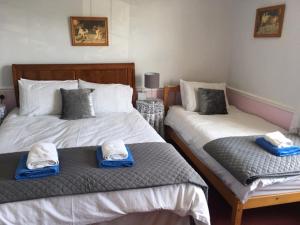 a bedroom with two beds with towels on them at The Old Alma Inn Ltd in Chilham