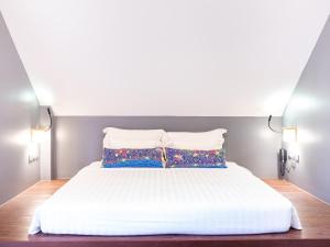 a bedroom with a white bed with two pillows at Deevana Krabi Resort in Ao Nang Beach