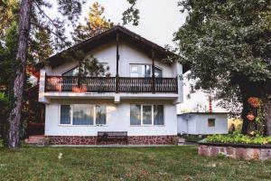 ein weißes Haus mit Balkon darüber in der Unterkunft Nature Guesthouse in Varshets