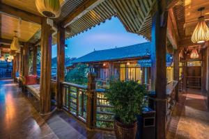 a house with a porch with benches and a balcony at The Ritz-Man Boutique Inn Lijiang in Lijiang