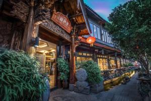 a building with a statue in front of it at The Ritz-Man Boutique Inn Lijiang in Lijiang