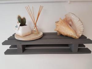 a shelf with a shell and other items on it at Sur la route des peintres in Champagne-sur-Oise