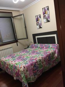 Un dormitorio con una cama con una colcha colorida. en Playa America!, en Nigrán 12 fotos más