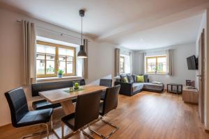 een woonkamer met een tafel en stoelen en een bank bij Haus Klingenschmid in Hopfgarten im Brixental