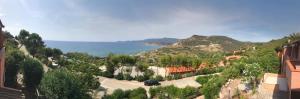 a view of a town with the ocean in the background at Appartamento relax Villaggio Turas in Magomadas