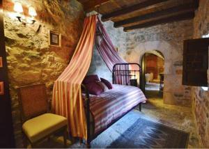 a bedroom with a canopy bed in a stone wall at Château du Cros in Le Cros