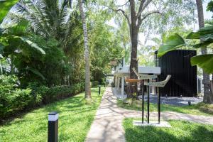 a path through a park with trees and a house at Deevana Krabi Resort in Ao Nang Beach