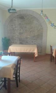 ein Esszimmer mit zwei Tischen und einer Backsteinwand in der Unterkunft Locanda Amato in Amato