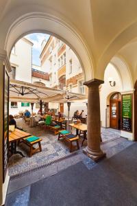 an outdoor patio with wooden tables and benches at Residence u Vejvodů in Prague