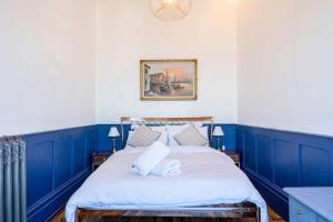 a blue and white bedroom with a large bed at Bellevue By The Bay - Luxury Beach Pad, Panoramic Sea Views in Herne Bay