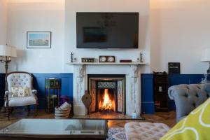 a living room with a fireplace with a tv above it at Bellevue By The Bay - Luxury Beach Pad, Panoramic Sea Views in Herne Bay