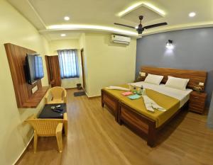 a bedroom with a bed and a tv in a room at Siva Residency in Mahabalipuram