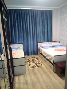 パヴロフスクにあるB&B Solnechniyのベッドルーム1室(ベッド2台、青いカーテン付)