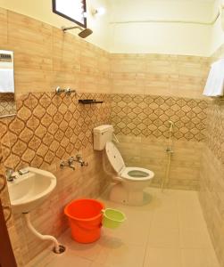 a bathroom with a toilet and a sink and a tub at Siva Residency in Mahabalipuram