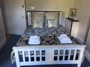 a white bed with two towels on top of it at The Old Alma Inn Ltd in Chilham