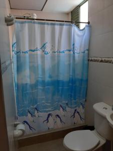 Baño con cortina de ducha con delfines. en Habitaciones Altos de Cooservicios en Tunja