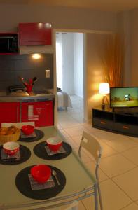 - une cuisine avec une table et 2 bols rouges dans l'établissement Brive Centre, à Brive-la-Gaillarde