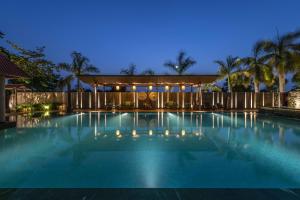 a swimming pool at night with lights on at Radhe Upavan Resort in Ahmedabad