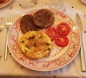 un plato de comida con patatas y tomates en una mesa en Back INN Time B&B, en Kilmarnock