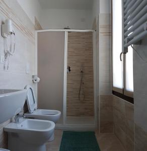 a bathroom with a shower with a toilet and a sink at Hotel Oregon in Milan