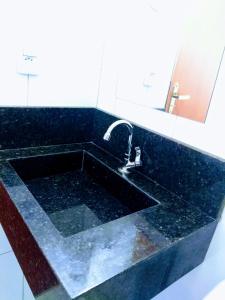 een badkamer met een zwart bad en een wastafel bij Pousada Recanto da Vila in Piranhas