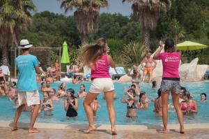 a group of people playing in a swimming pool at Camping Le Méditerranée Argelès - Domaine piétonnier in Argelès-sur-Mer