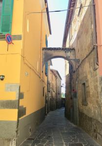 an alley with an arch between two buildings at Alessia House in Bagnoregio