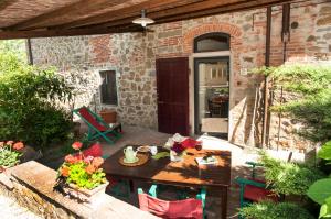 een patio met een tafel en stoelen en een gebouw bij I Gelsi in Figline Valdarno