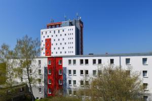 a tall white building with a red building at SKYBASIC Merseburg in Merseburg