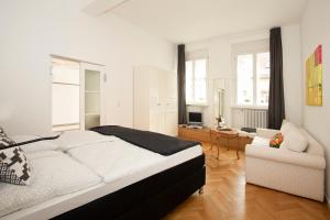 a white bedroom with a bed and a couch at ROMEO & JULIA ZENTRAL in Bamberg