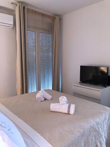 a bedroom with a bed with towels and a tv at Apartment Marija in Split